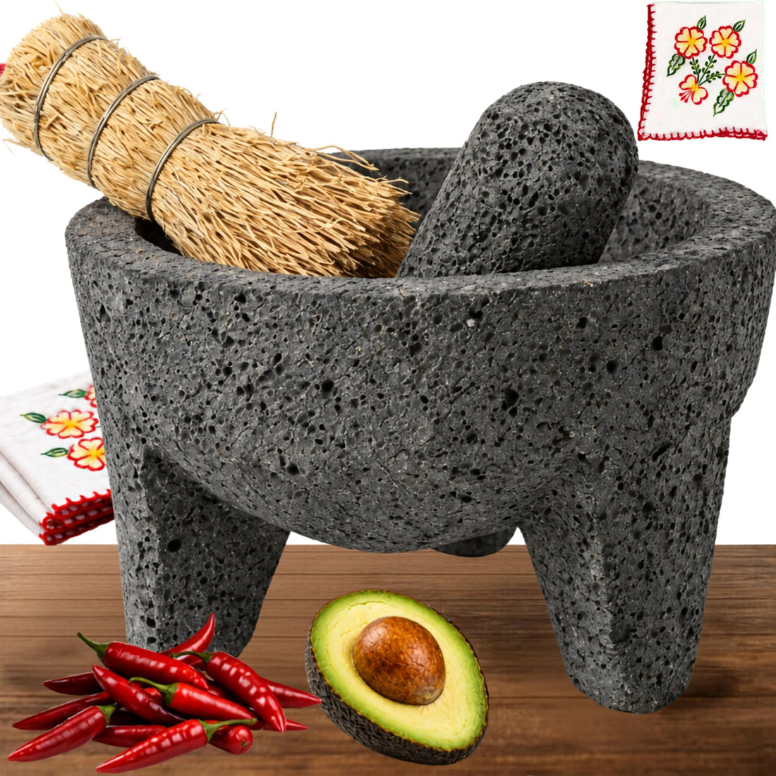 Volcanic stone molcajete with a cleaning brush, chiles and avocado