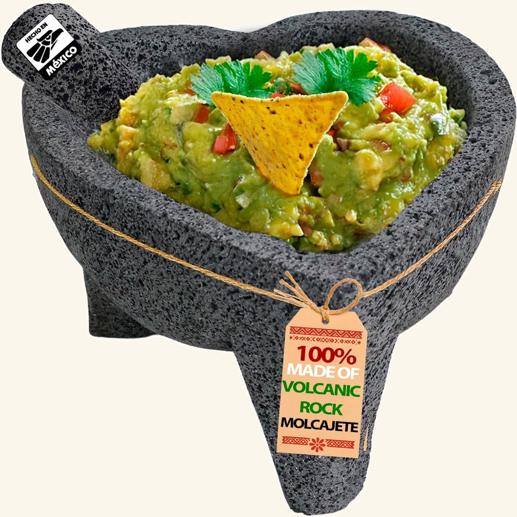 Heart molcajete with 3 legs made of volcanic rock, filled with guacamole