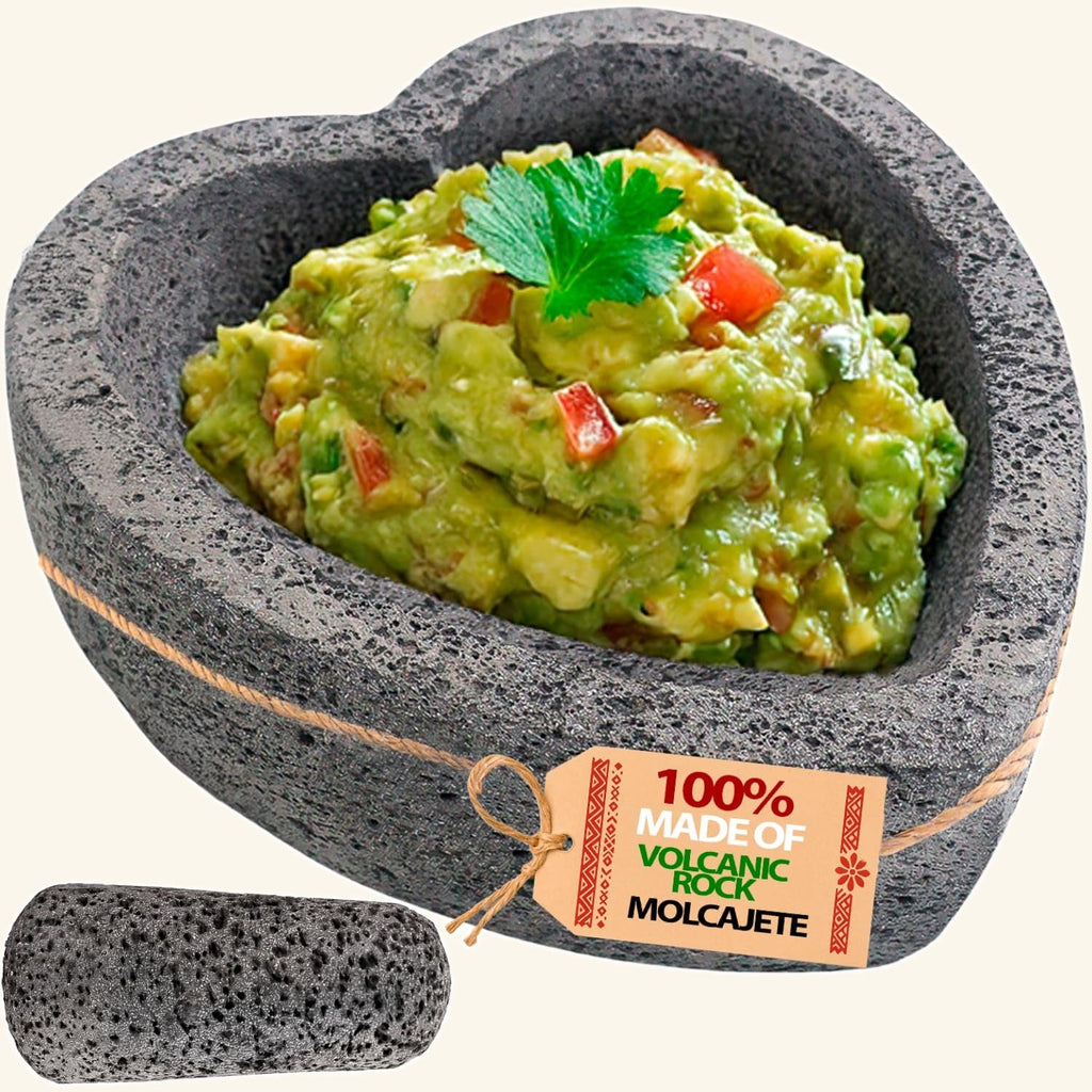 Flat base heart molcajete made of volcanic rock, filled with guacamole