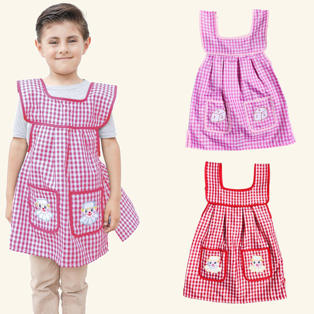 Girl wearing the pink gingham kids apron, with the pink and red aprons of the 2 pack