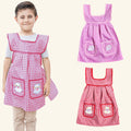 Girl wearing the pink gingham kids apron, with the pink and red aprons of the 2 pack
