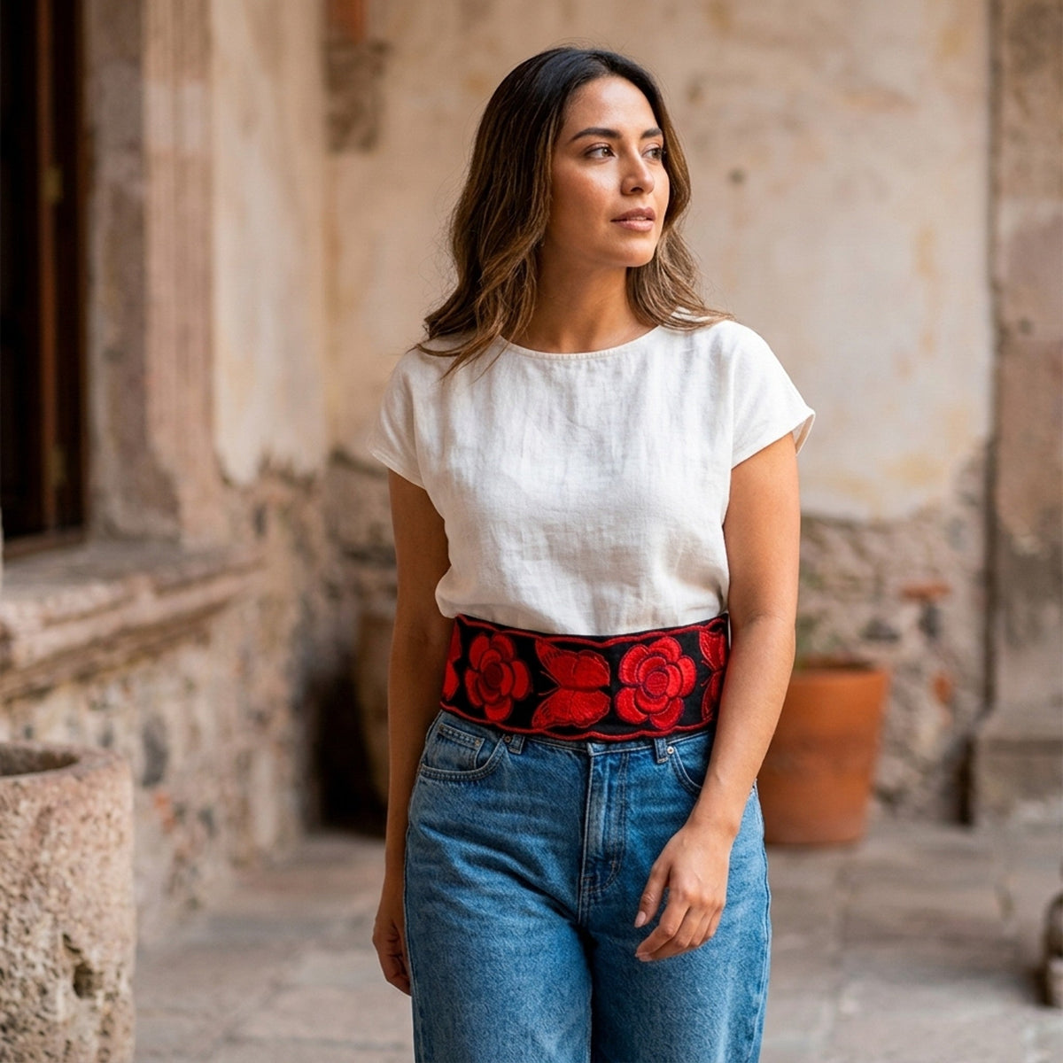 Red floral embroidered Mexican belt worn over a white tee and jeans
