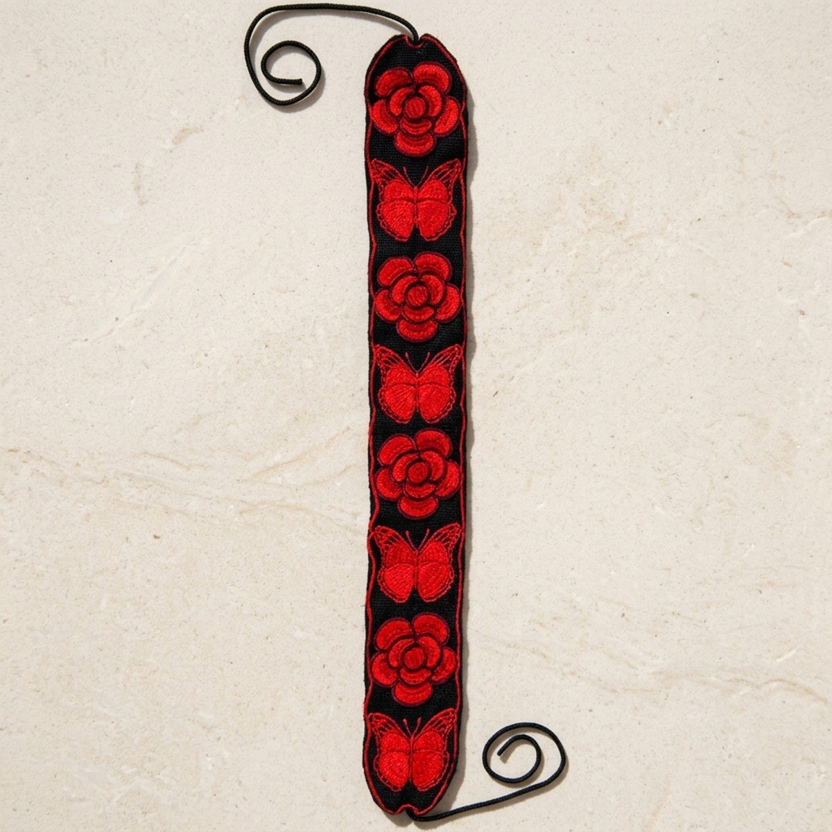 Red floral embroidered Mexican belt with roses and butterflies shown full length with tie cords