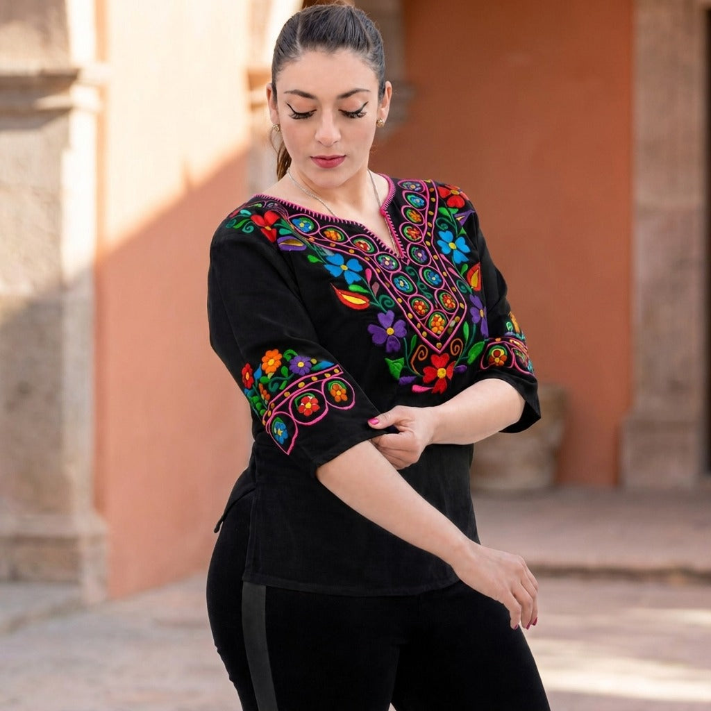 Black embroidered Mexican blouse with three quarter sleeves in a terracotta courtyard