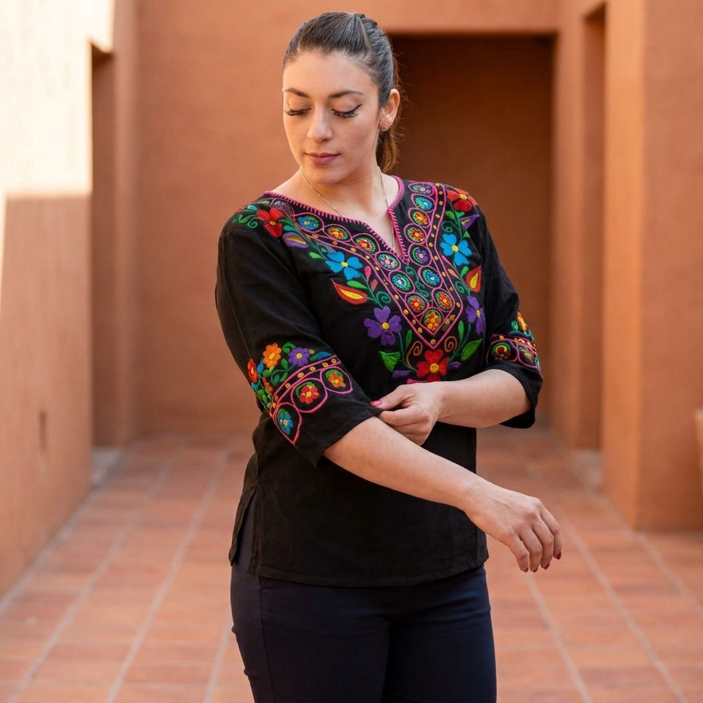Woman in the black embroidered Mexican blouse in a terracotta hallway