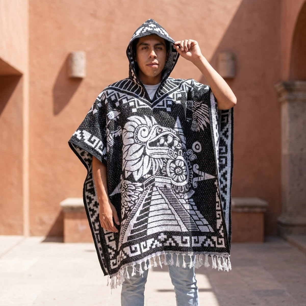 Aztec Mexican poncho worn with the hood up in a terracotta courtyard