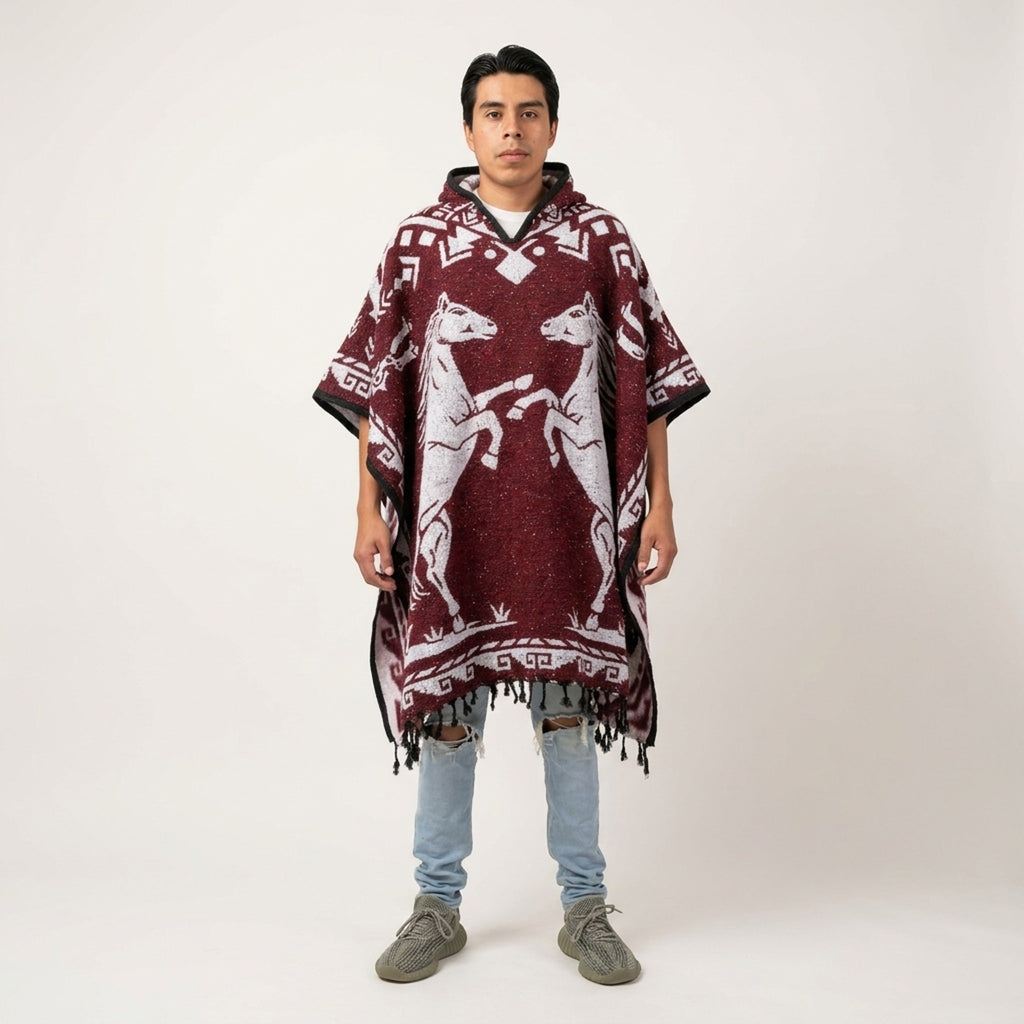 Model wearing the Red Horse hooded Mexican poncho in burgundy with two rearing horses, studio front view