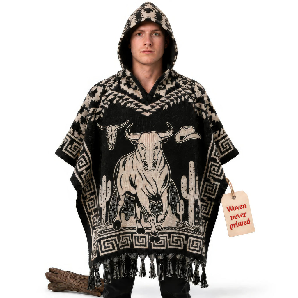Model wearing the Charro Bull Rider hooded Mexican poncho in black and cream with a charging bull, front view on white